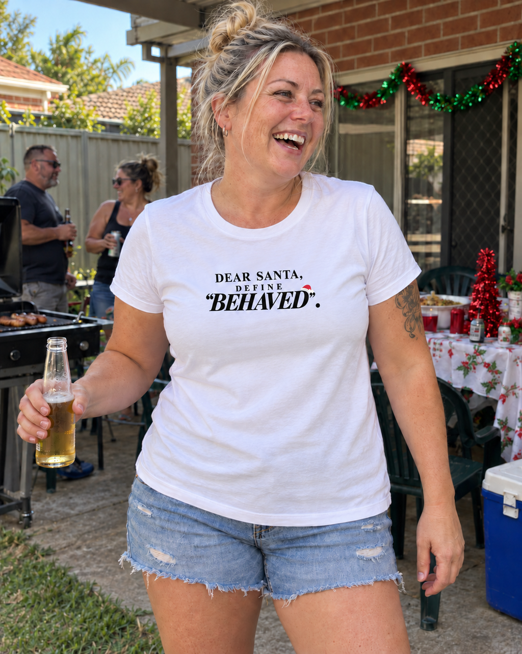 Woman wearing the white Dear Santa Define Behaved tee at an Australian Christmas BBQ — AI-generated styling mockup